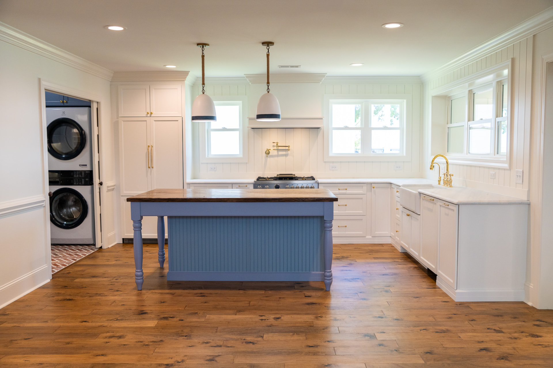 Kitchen & Scullery — Painted island with a reclaimed timber top, custom vent hood and an adjoining laundry room finished in patterned brick tile.
