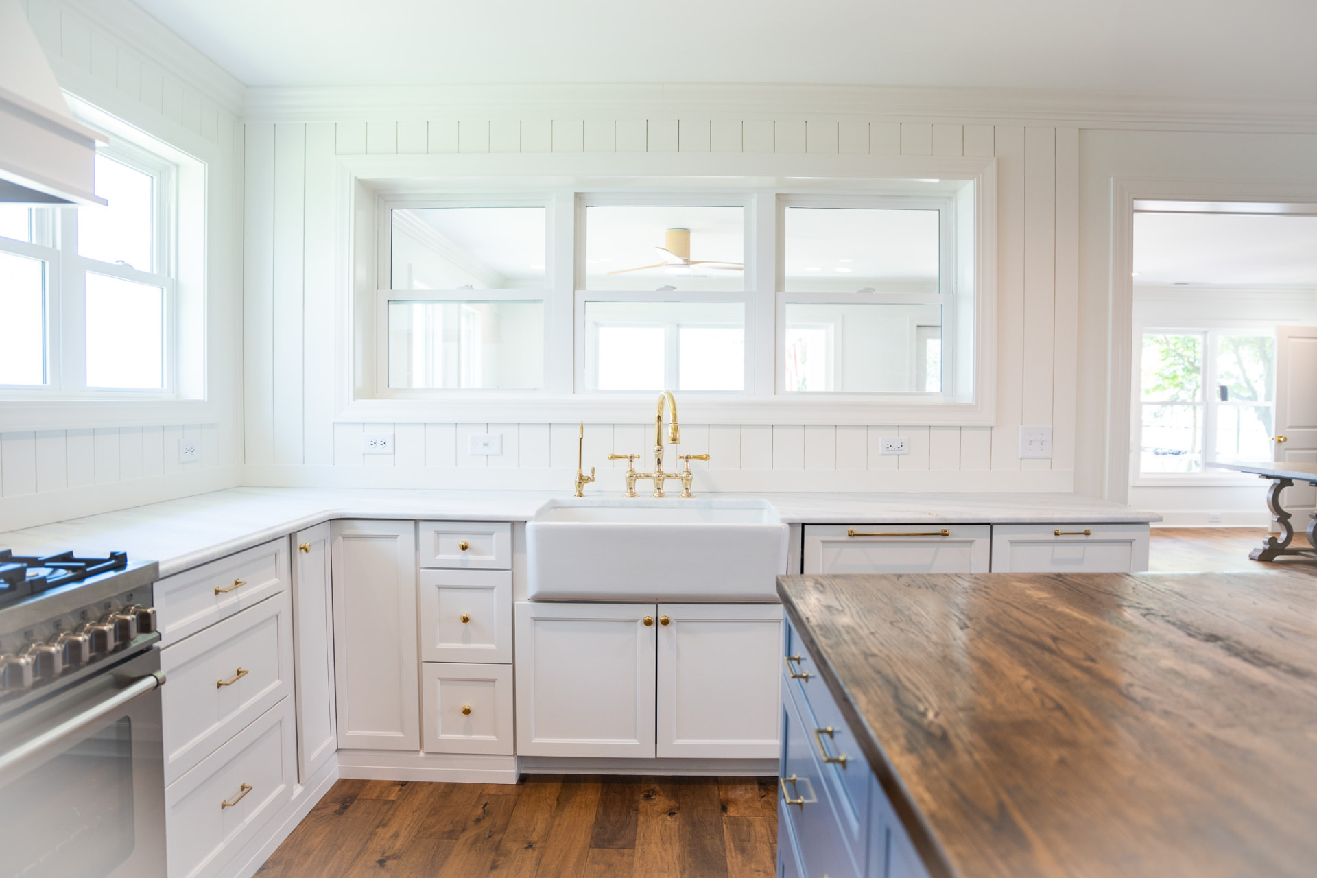 Custom kitchen with shiplap walls, marble counters and brass fixtures in a completed JT Williams residence